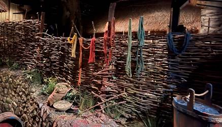 A woven wall with colorful yarn from it
Description automatically generated